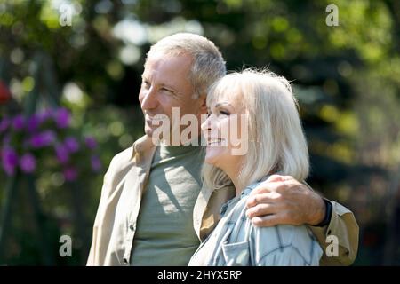 Happy loving senior spouses embracing and enjoying warm spring days, spending time together outdoors Stock Photo