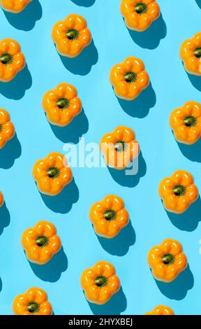 Polka dot pepper pattern on vibrant neon blue background, healthy eating and vegan concept Stock Photo
