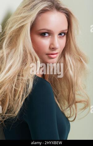 Her beauty is magnetic. Portrait of a gorgeous young model with wild, blonde hair looking at you confidently. Stock Photo