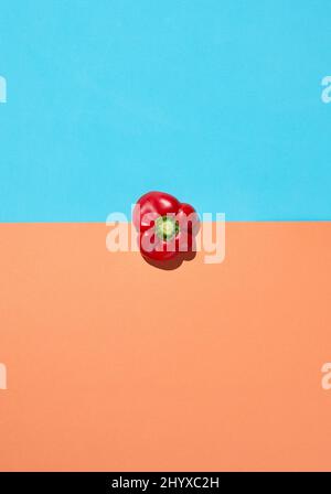 Contrasted top view with single red pepper on minimal pastel background, healthy eating and vegan concept, copy space Stock Photo