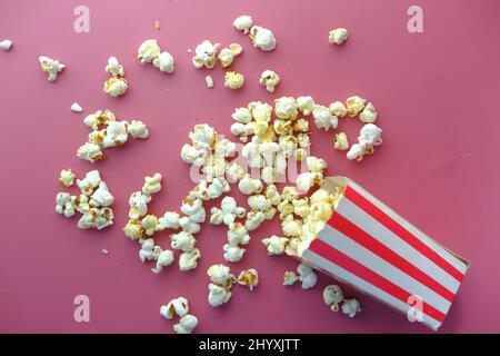 popcorn spilling from a container on red background  Stock Photo