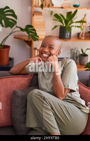 A young woman poses in a cute way with hands under chin at home Stock Photo