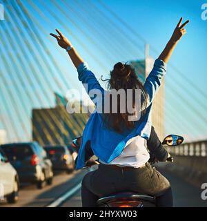 Find your zen along the road. Cropped shot of a young attractive couple riding a scooter around town. Stock Photo