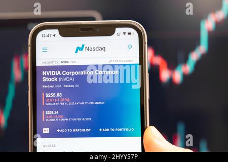 NVIDIA NVDA logo of stock price on the screen of smartphone in mans hand with changing trend on the chart on the background, February 2022, San Francisco, USA. Stock Photo
