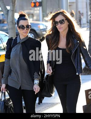Wearing a black cape over her grey top and carrying a black Louis Vuitton  handbag, Kim Kardashian is joined by Pussycat Dolls founder Robin Antin for  a day of luxury. The two