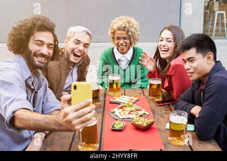 Happy friends taking selfie during gathering Stock Photo