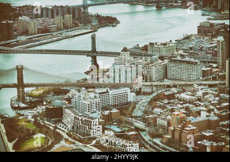 New York City from helicopter point of view. Brooklyn and Manhattan Bridges with Manhattan skyscrapers on a cloudy day. Stock Photo