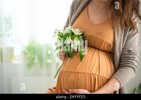 Hands showing a pregnancy belly cast decorated with lace and flower Stock  Photo - Alamy