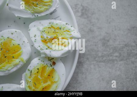 halves of a boiled eggs on a plate with space for text Stock Photo