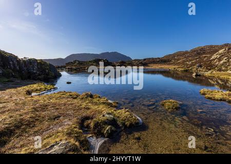 A partially frozen Innominate Tarn in winter in the Buttermere Fells, Lake District, England Stock Photo