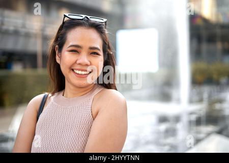 Portrait of an asian woman smiling to the camera outdoors Stock Photo