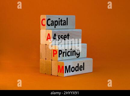 CAPM capital asset pricing model symbol. Concept words CAPM capital asset pricing model on blocks on a beautiful orange background. Business CAPM capi Stock Photo