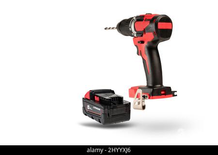 cordless tool isolated on white background. Cordless screwdriver with a drill inserted into the chuck and an extra battery on a white background. Stock Photo
