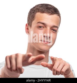 The young man points forward with his fingers. On a white background. Stock Photo