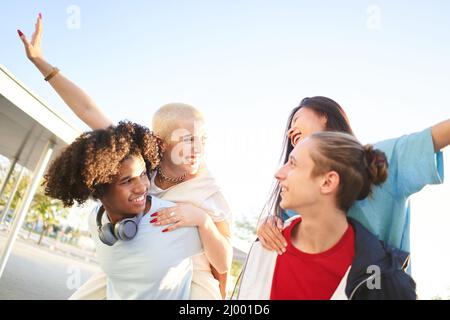 Group of students on city street smiling. Young people having fun on vacation. Stock Photo