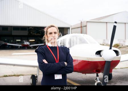 Young female pilot posing in front of her plane. Stock Photo