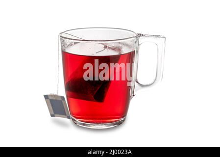 Red fruit herbal tea, herbal tea infusion bag in transparent glass cup isolated on white, clipping path Stock Photo