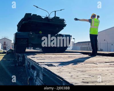 Mannheim, Germany. 14 March, 2022. A worker assists in loading a U.S. Army M1A2 Abrams main battle tank onto a German rail car at Coleman worksite March 14, 2022 in Mannheim, Germany. The U.S. military is moving an entire armored brigade from prepositioned stocks to Grafenwoehr Training Area as NATO enhances security following the Russian invasion of Ukraine.  Credit: Maj. Allan Laggui/U.S Army/Alamy Live News Stock Photo