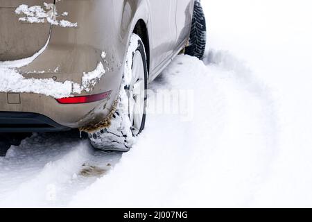 Detail of car tires on winter road covered with snow Stock Photo