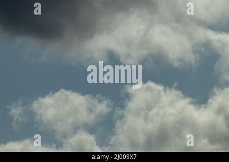 puffy storm clouds gathering against blue sky Stock Photo
