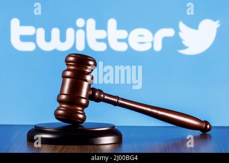 Gavel on table against background of Twitter social network logo. The concept of trial. Stock Photo