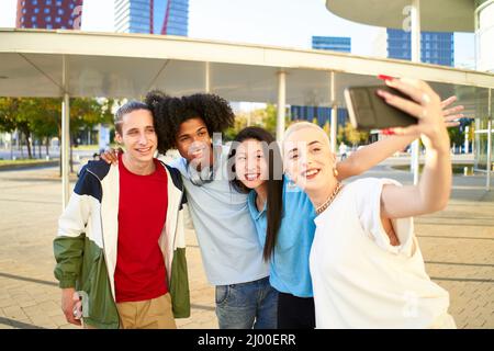 Happy centennial people taking smiling selfie. Group of students together at campus university  Stock Photo