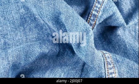 wrinkled jeans fabric, not flat, with hollows and waves, blurred Stock Photo