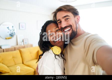 Happy people enjoying at home. Girlfriend and boyfriend taking smiling photo looking at camera. Couple in love Stock Photo