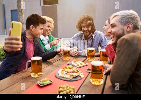 friends taking selfie and drinking beer at bar Stock Photo
