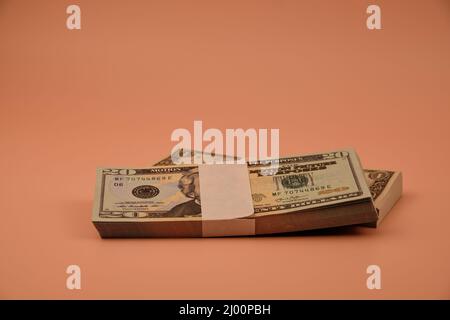 Bundles of dollar bills on top of a table with an orange color. Stock Photo