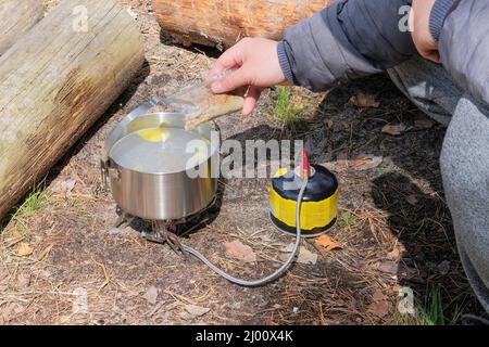 Camping food making. Tourist foods in outdoor activities. Food in bowler in the wild forest. Stock Photo