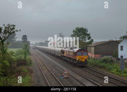 DB Cargo rail UK class 66 locomotive 66183 passing Ashchurch for Tewkesbury with a freight train of empty Castle cement tanks Stock Photo