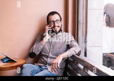 Young caucasian man smiling happy talking on the smartphone Stock Photo
