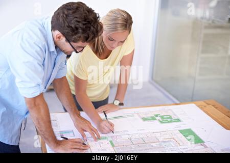 Planning out the fine details. Two architects discussing elements of an architectural plan. Stock Photo