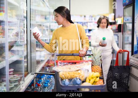 Hispanic woman shopping for milk products in supermarket Stock Photo