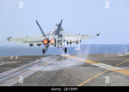 Philippine Sea, United States. 15 March, 2022. A U.S. Navy EA-18G Growler fighter jet, attached to the Wizards of Electronic Attack Squadron 133, launches off the flight deck of the Nimitz-class aircraft carrier USS Abraham Lincoln during routine operations, March 15, 2022 in the Philippine Sea.  Credit: MC3 Javier Reyes/Planetpix/Alamy Live News Stock Photo