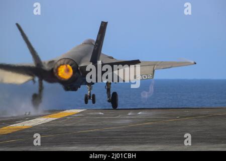 PHILIPPINE SEA (March 15, 2022) An F-35C Lightning II, assigned to the 'Black Knights' of Marine Fighter Attack Squadron (VMFA) 314, launches from the flight deck of the Nimitz-class aircraft carrier USS Abraham Lincoln (CVN 72) to conduct a joint long-range air demonstration in the Yellow Sea, March 15. Abraham Lincoln Strike Group is on a scheduled deployment in the U.S. 7th Fleet area of operations to enhance interoperability through alliances and partnerships while serving as a ready-response force in support of a free and open Indo-Pacific region. (U.S. Navy photo by Mass Communication Sp Stock Photo
