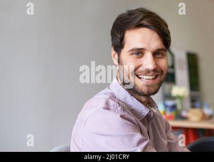 How can you resist that face. A handsome young businessman smiling at the camera. Stock Photo