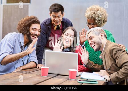 Video call of a Group of students outdoors. Colleagues working togethers casual online classes. Millennial people using laptop Stock Photo