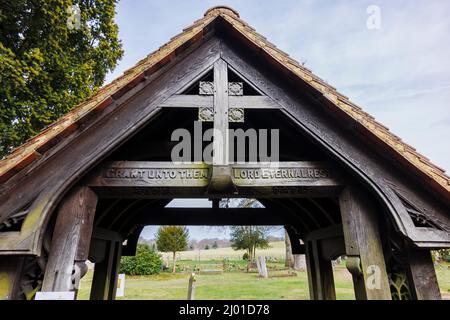 Lych gate with inscription at the entrance to St Michael and All Angels church in Pirbright village, near Woking, Surrey, south-east England Stock Photo