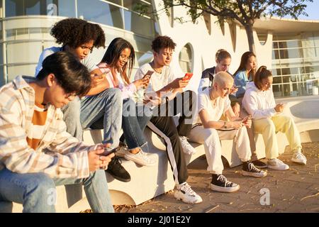 Group of young technology addicts using mobile smartphone outdoor. Multi ethnic millennial generation no social with new trends social media apps Stock Photo