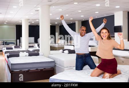 Couple delighted with mattress bought in shop Stock Photo