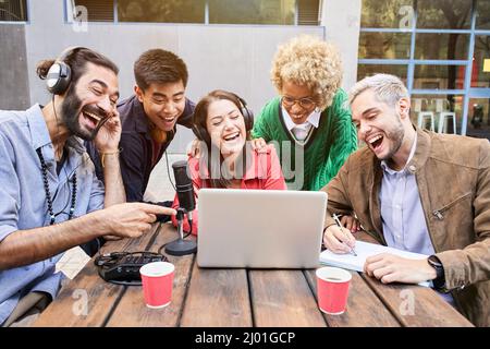 Young people in video call with casual studio broadcasting. Woman interviewed a man for a podcast outdoors. Stock Photo
