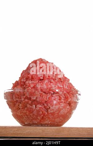 minced pork. fresh raw minced meat in a cup on a wooden table isolated on white background.Minced meat texture.Meat products.Ground fresh meat  Stock Photo