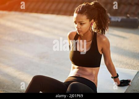 You deserve that break. Shot of a young woman taking a break from her workout. Stock Photo