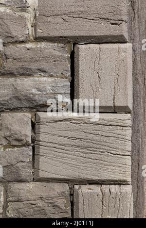 Close-up of loose and cracked mortar joints between grey stones in building wall. Stock Photo