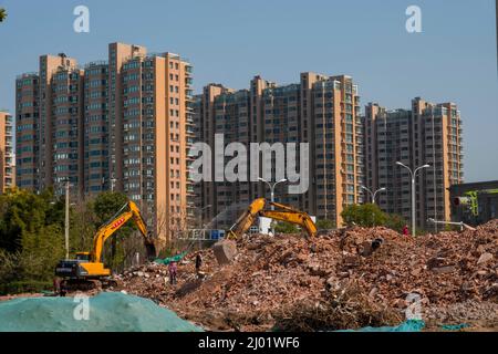 HAIAN, CHINA - MARCH 9, 2022 - Workers operate construction machinery to demolish old buildings in Haian city, East China's Jiangsu province, March 9, Stock Photo