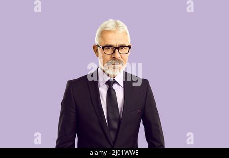 Senior businessman in suit and glasses looking at camera with serious expression Stock Photo
