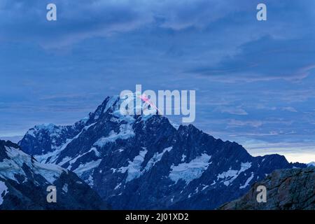 The glow of sunrise on the peak of Mount Cook, viewed from Mueller hut, Aoraki/Mount Cook National Park, south island, Aotearoa / New Zealand. Stock Photo