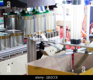Production line of automation robot lifting food can into carton in food industry. Stock Photo